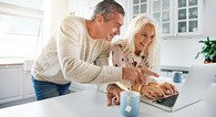 Caucassion_couple__happy_at_computer_AdobeStock_141181477