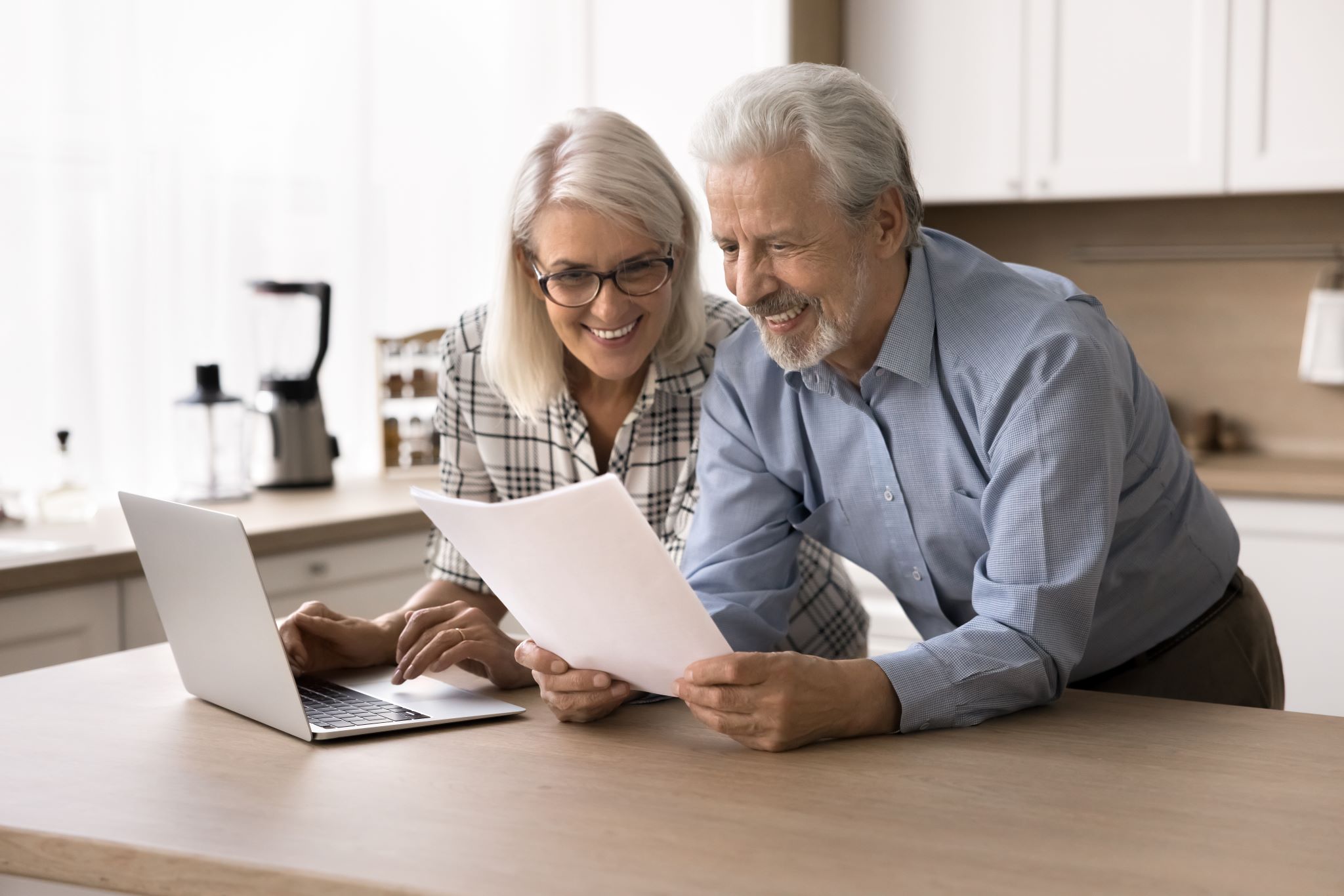Elder_Couple_holding_documents_COMPRESSED_AdobeStock_952634963